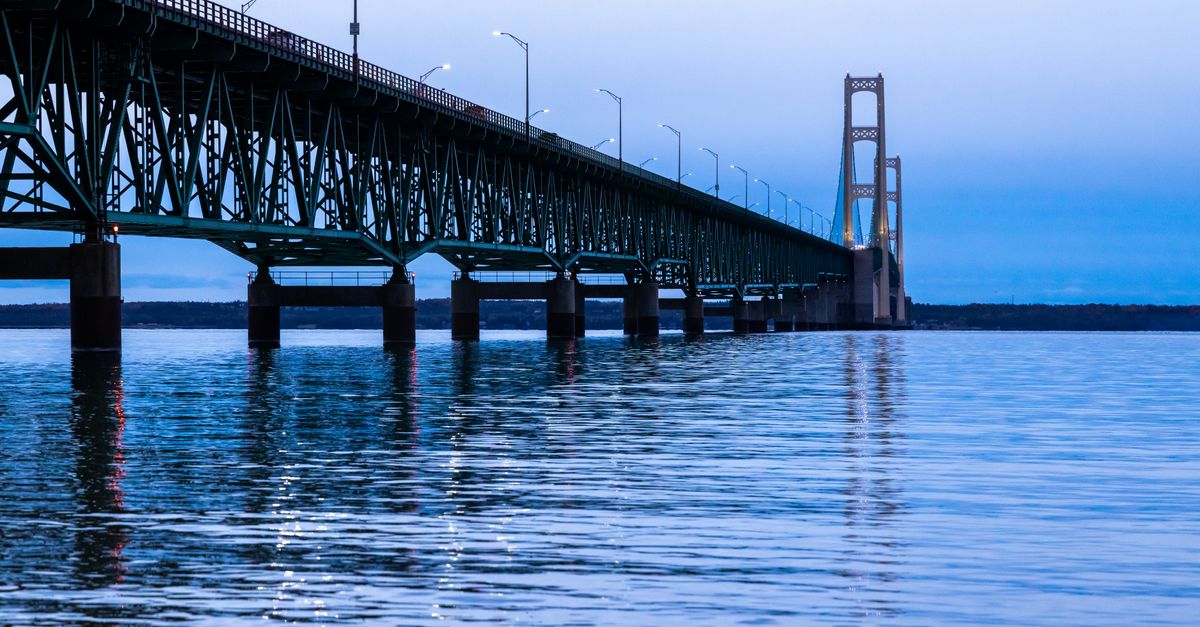 Stunning view of Mackinac Bridge extending into Lake Michigan during twilight hours.